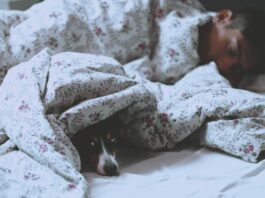 man is having better sleep on bed with white printed blanket
