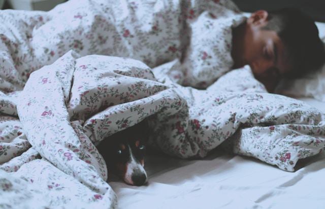 man is having better sleep on bed with white printed  blanket 